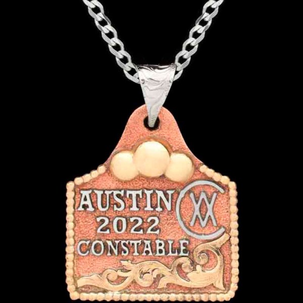 Meet our Muffin Cow Tag Necklace, crafted on a hand matted copper base, adorned with golden Jeweler's Bronze scrollwork and a charming bead edge. Customize it with your lettering and ranch brand now!